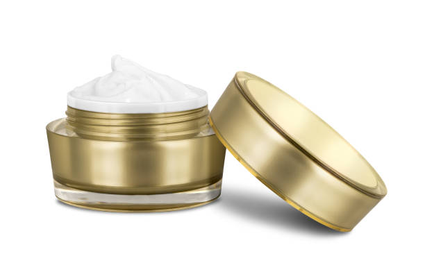 Luxury cosmetic face moisturizing smudged white cream for aged skin in open glossy golden can with matching lid, isolated on white background, clipping path included Luxury cosmetic face moisturizing smudged white cream for aged skin in open glossy golden can with matching lid, isolated on white background, clipping path included face cream stock pictures, royalty-free photos & images