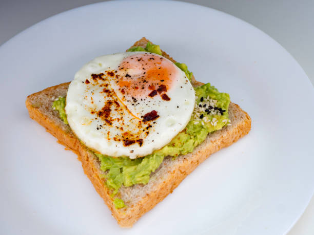 istock Appetizing bruschetta with egg and avocado on a plate. 1135898561