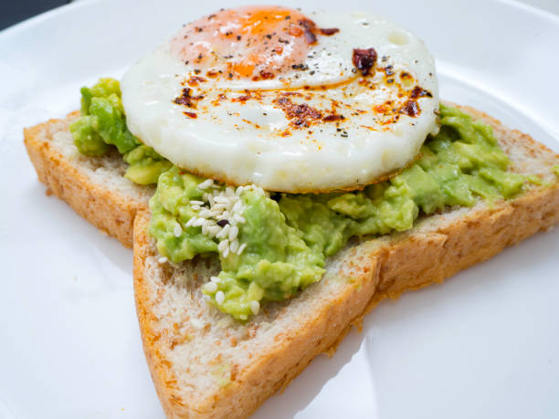 Appetizing bruschetta with egg and avocado on a plate.