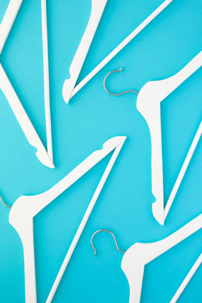 istock White wooden hangers on blue background 1135900650