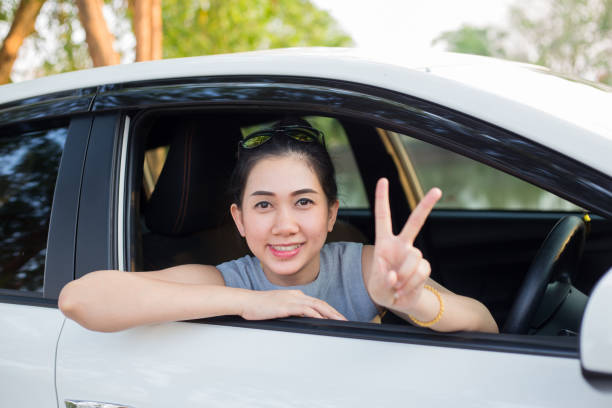istock Cute young lady happy driving car 1135904390