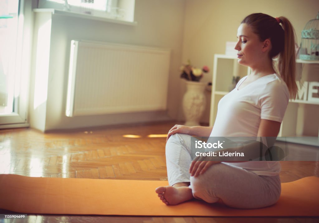 Keeping baby healthy. Keeping baby healthy. Pregnant woman working yoga. Pregnant Stock Photo