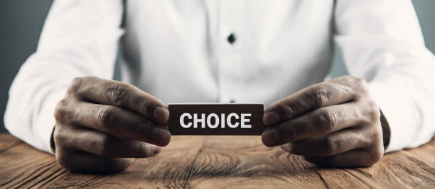 istock Man holding wooden cube with Choice word. 1135904829