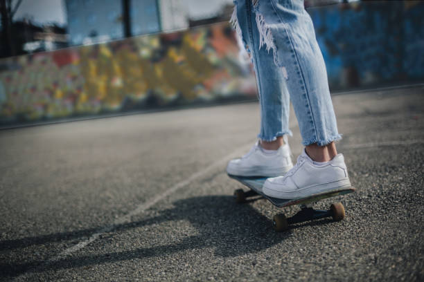 Attractive Female Skateboarder is Having a Fun  Beautiful Young Woman is Enjoying in Spring Day and is Driving Longboard in the Street.