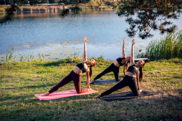 istock Women doing yoga on the lake 1135908176