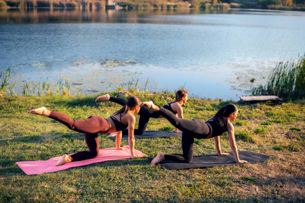 istock Women doing yoga on the lake 1135908206