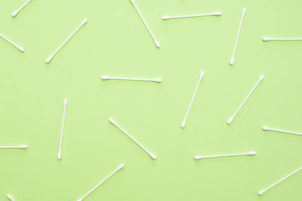 istock White cotton swabs on green background lie in random order. 1135918046
