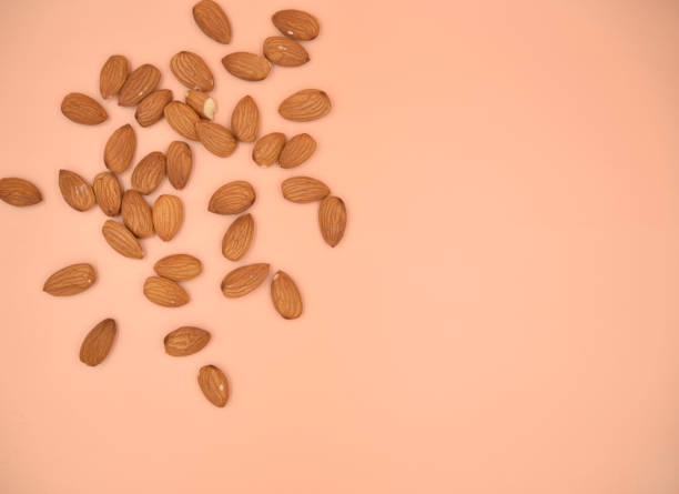 istock Isolated almond nuts on the live coral solid background 1135921504