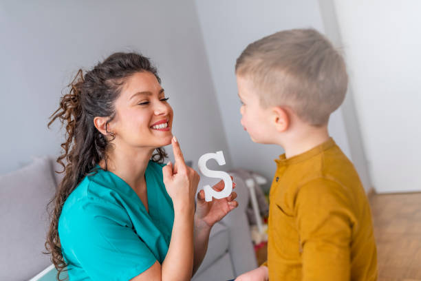 Speech therapist and little patient training articulation Speech therapist and little patient training articulation. Speech therapist teaches the boys to say the letter S. Shot of a speech therapist during a session with a little boy communication problems stock pictures, royalty-free photos & images