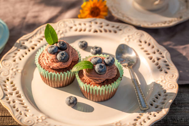 istock Chocolate muffin with fresh blueberries and cream on plate 1135922378