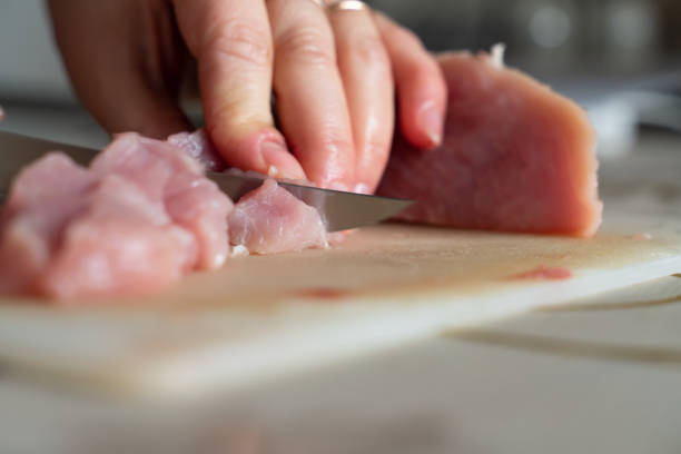 chopped meat food processing in the kitchen with knife with white chopping board