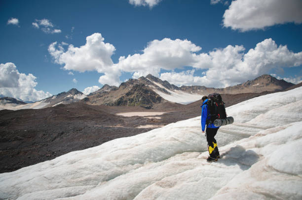 istock A mountaineer with a backpack walks in crampons walking along a dusty glacier with sidewalks in the hands between cracks in the mountain 1135923432