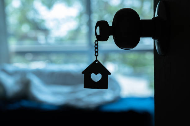 House key with home keyring in keyhole on wood door, copy space House key with home keyring in keyhole on wood door, copy space lock photos stock pictures, royalty-free photos & images