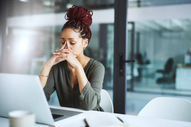 She has one too many deadlines to deal with Shot of a young businesswoman looking stressed out while working in an office banging your head against a wall stock pictures, royalty-free photos & images