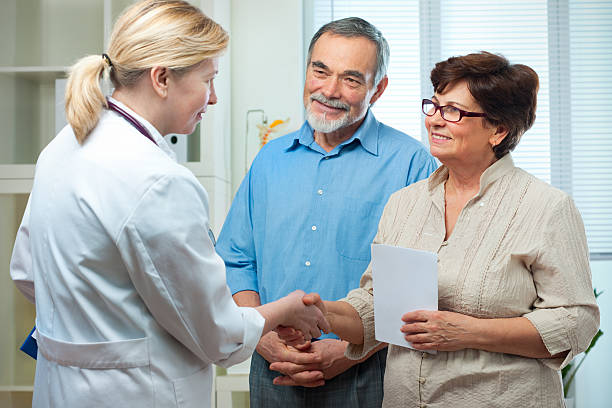 presso l'ufficio del medico - discussion couple senior adult inside of foto e immagini stock