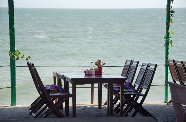 istock A table with chairs in a cafe under a canopy on the beach. 1135929362