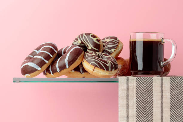 istock Chocolate donuts and black coffee on a pink background. 1135929614