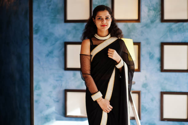 Young indian woman wear at elegant black saree posed on restaurant Young indian woman wear at elegant black saree posed on restaurant against wall with frames. maiden stock pictures, royalty-free photos & images