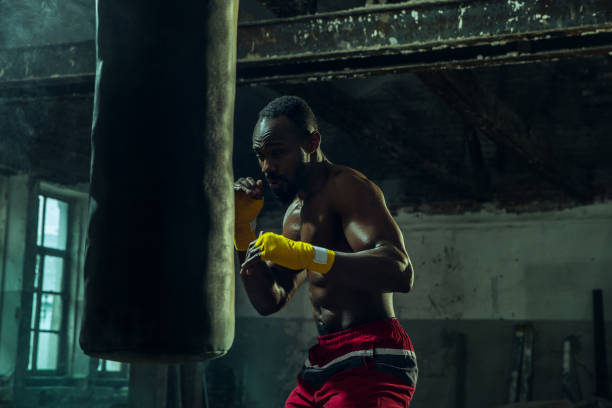 istock Hand of boxer over black background. Strength, attack and motion concept 1135930834