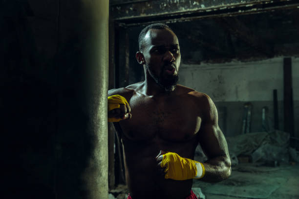 istock Hand of boxer over black background. Strength, attack and motion concept 1135930841