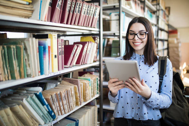 istock Portrait of college student studying in the library using tablet PC 1135933829