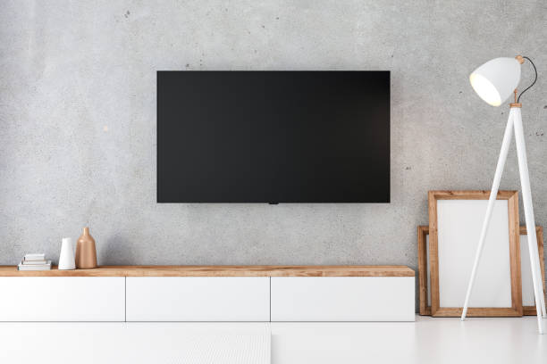 istock Smart Tv Mockup with blank screen hanging on the concrete wall in modern interior 1135934039