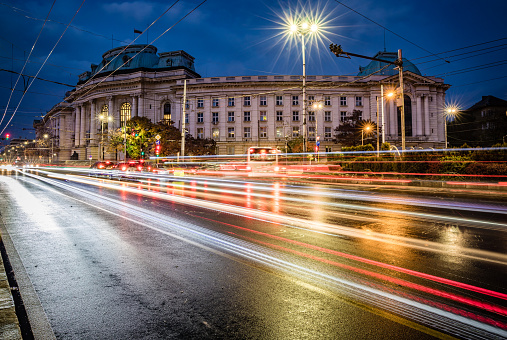 Twilight long exposure cityscape in downtown Sofia city centre in Bulgaria, Eastern Europe. Including the illuminated main building of National University in Sofia with blurred lights from the road traffic on the boulevard. Shot on Canon full frame EOS R full frame system with tripod. Image is great for background with extra copy space for your message.