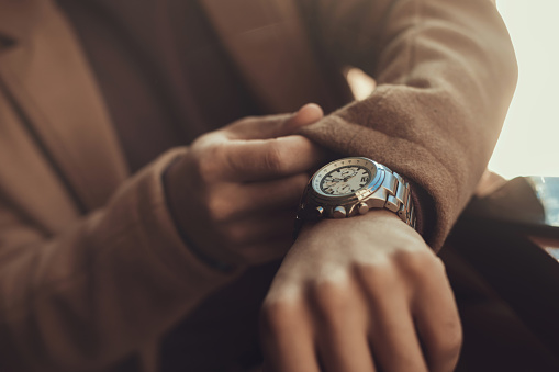 Being punctual. Close up male hand with stylish silver watch