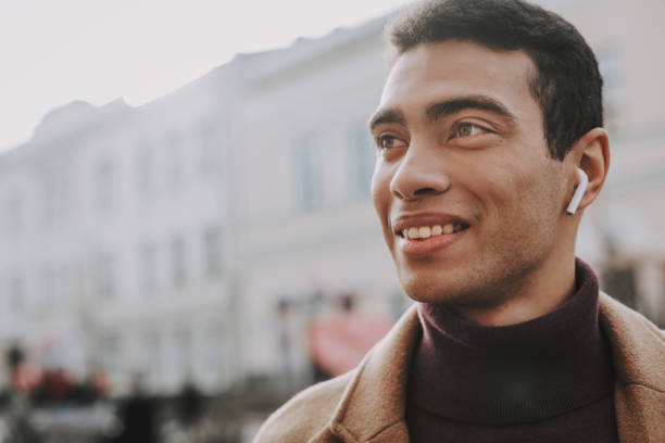 istock Handsome young man using wireless earphones while spending time outdoors 1135935071