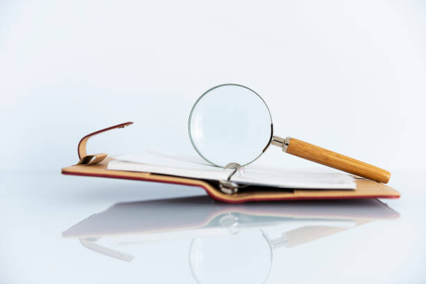 istock notebook with magnifying glasses isolated on white background 1135935214