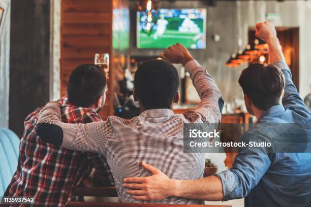 Trzech Mężczyzn Oglądających Piłkę Nożną W Telewizji W Barze - zdjęcia stockowe i więcej obrazów Piłka nożna - Sport drużynowy