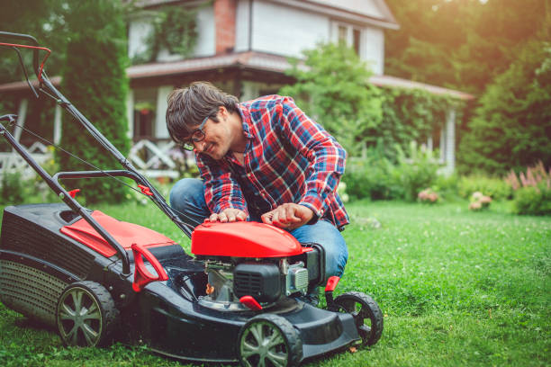 mężczyzna sprawdza kosiarkę na swoim podwórku - lawn mower red plant lawn zdjęcia i obrazy z banku zdjęć