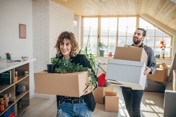 istock Couple carrying boxes in new home 1135938484