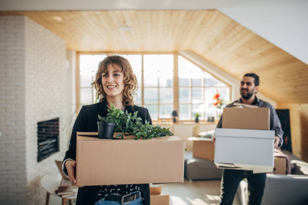 istock Couple carrying cardboard boxes in new home 1135938573