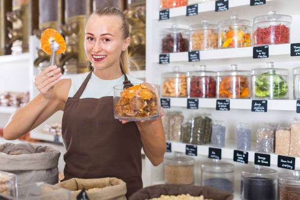 istock Young woman is offering dried orange in container 1135938601
