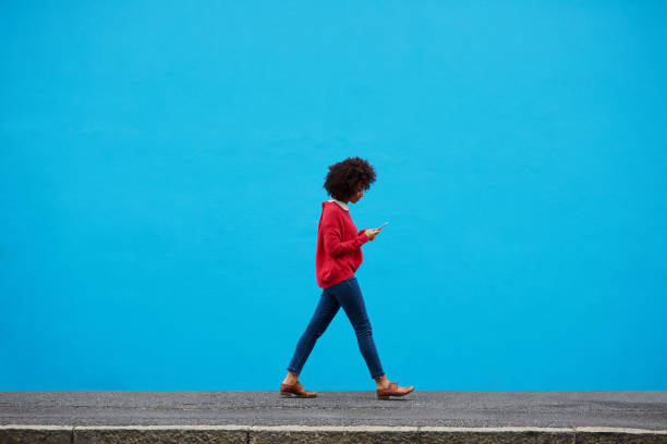 I have so many followers in the city Shot of a fashionable young woman using her cellphone while walking through the city telecommunications equipment photos stock pictures, royalty-free photos & images