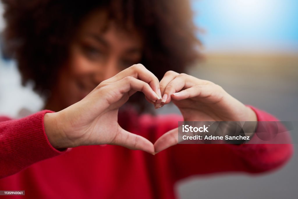 Love everything Cropped shot of an unrecognizable woman forming a heart shape with her fingers Heart Shape Stock Photo