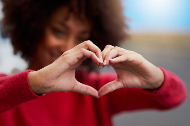 Love everything Cropped shot of an unrecognizable woman forming a heart shape with her fingers heart shape photos stock pictures, royalty-free photos & images