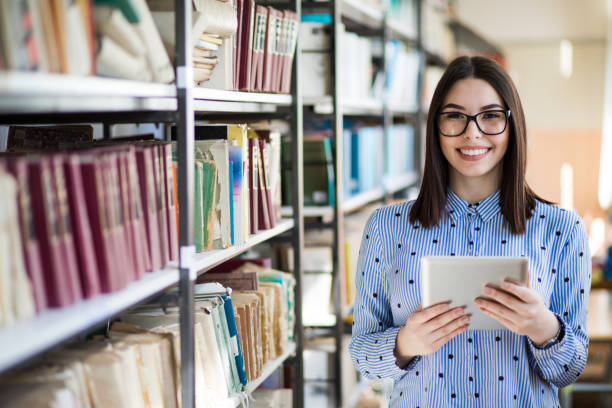 Portrait of a gorgeous student using a tablet computer in a library stock photo