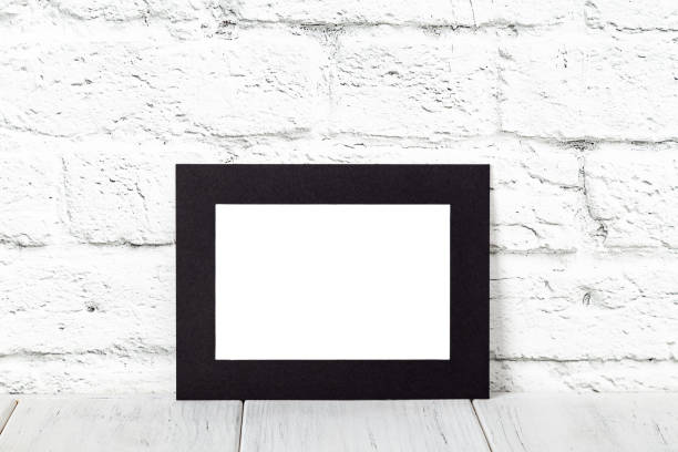 Horizontal black photo frame on wooden table. Mockup with copy space stock photo