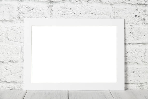 White empty photo frame against brick wall. Mockup with copy space stock photo