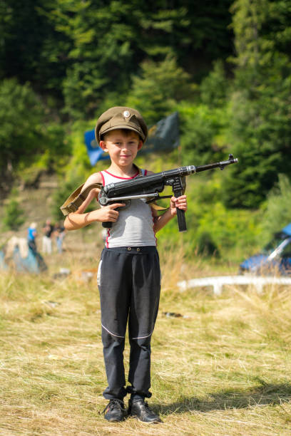 istock A little boy in his cap holds a trophy weapon MP-40 from the Second World War 1135943515