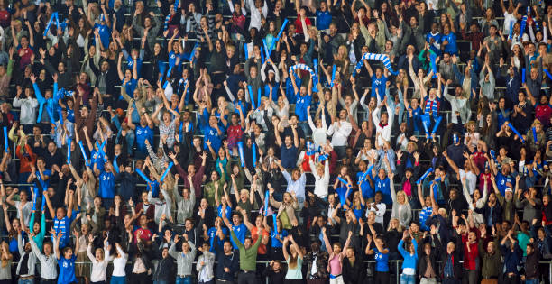 Spectators watching match in stadium Blurred motion of crowd of fans cheering and celebrating while watching match in stadium. crowded stock pictures, royalty-free photos & images