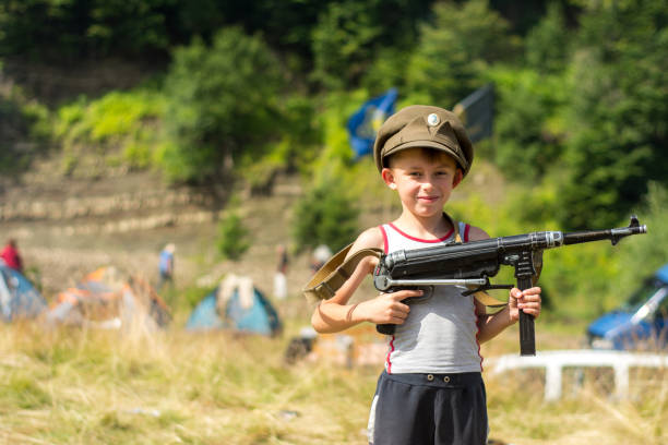 istock A little boy in his cap holds a trophy weapon MP-40 from the Second World War 1135943606