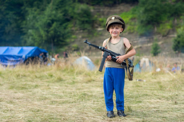 istock A little boy in his cap holds a trophy weapon MP-40 from the Second World War 1135943749