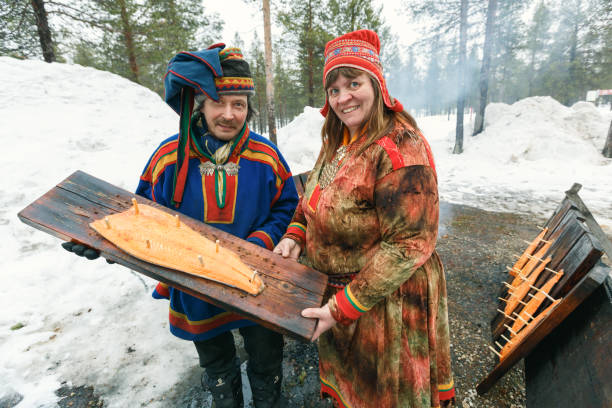 samiskt par med trä skiva med rökt lax filé lagad i brand i finland - same direction bildbanksfoton och bilder