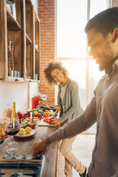 istock Happy african-american couple cooking dinner in kitchen 1135943977