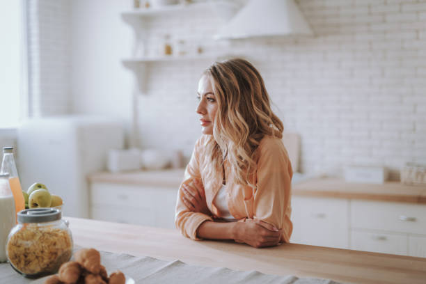 istock Thoughtful woman looking into the distance while standing in the kitchen 1135944174