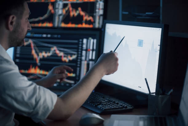 istock Analyzing data. Close-up of young businessman pointing on the data presented in the chart with pen while working in creative office 1135944360