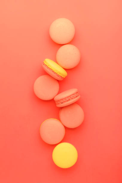 istock Pink yellow macaroons on soft pink background table, place for text, minimalism style, top view 1135946013
